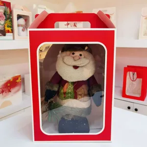 Detailed view of a festive red gift box with transparent window for doll packaging.