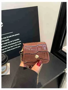 Detailed view of brown mini stone-pattern crossbody bag with gold chain and clasp.