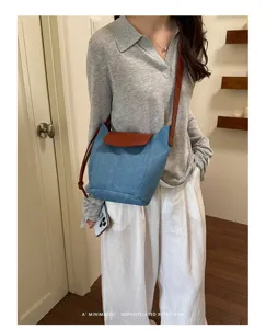 Bolso bandolera de mezclilla para mujer con solapa en contraste, estilo elegante y casual.