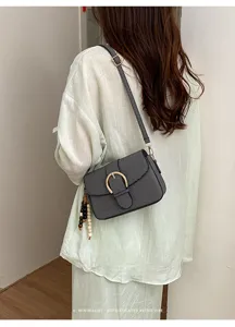Retro casual women's shoulder bag with metal buckle and chic beaded pendant for daily use.