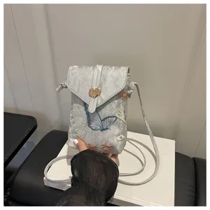 Vista dettagliata di una mini borsa a tracolla ricamata chic con graziosi motivi di farfalle e fiori.