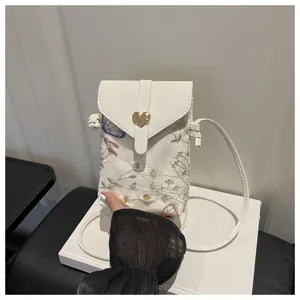 Borsa a tracolla bianca ricamata per telefono con motivo floreale e chiusura a cuore.