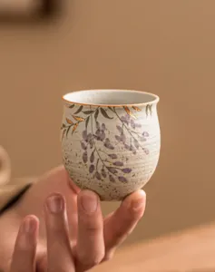 Handmade ceramic tea cup with wisteria flower painting and gold foil for daily home tea use.