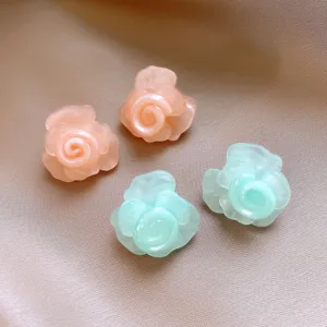 Detailaufnahme süßer Harz-Rosen-Ohrstecker in Rosa und Mintgrün, eleganter Blumenschmuck.