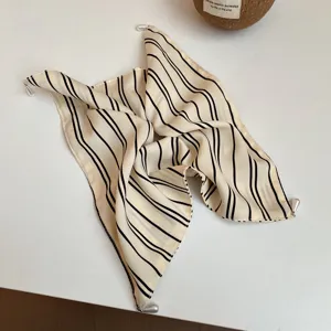 Gedetailleerd overzicht van chic gestreepte stoffen haarband met parelhangers, trendy.