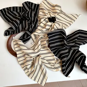 Detail van gestreepte stoffen haaraccessoire in Koreaanse stijl met elegante parelversiering.