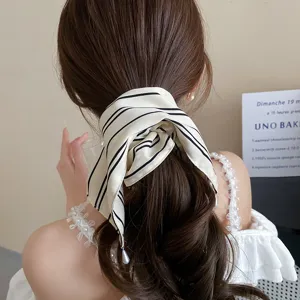 Elegante zwart-wit gestreepte haarscrunchie met parelhangertje voor stijlvol haaraccessoire
