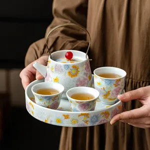 Service à thé en céramique traditionnelle à motif floral coloré, théière et tasses.