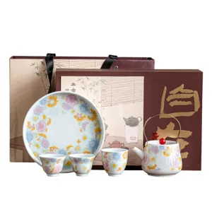 Service à thé en céramique de style traditionnel chinois avec théière, tasses et assiette.