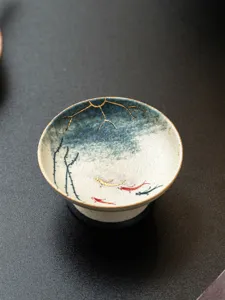Taza de té de cerámica pintada a mano con motivo de carpa koi, detalle elegante.