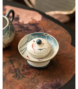 Portatapas de té de cerámica pintado a mano con diseño de loto y carpa koi, vista de detalle.