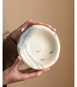 Close-up detail of hand-painted ceramic tea tray featuring elegant koi fish and gold accents.