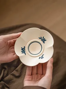 Detail van handgeschilderde keramische theekop onderzetter, hittebestendig voor thee.