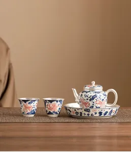 Exquisite silver-plated ceramic teapot and cups detail view with goldfish motif design.
