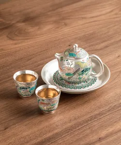 Detailed close-up of exquisite silver tea set featuring traditional fish and algae pattern.