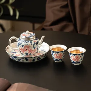 Goldfish pattern silver-gilt tea set with teapot, tray and two cups for traditional brewing.