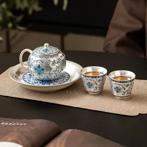Silver plated ceramic kung fu tea set with one pot and two cups, elegant floral pattern.