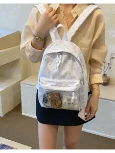 Chic white polka dot canvas backpack for women, clear front pocket with cute plush toys.