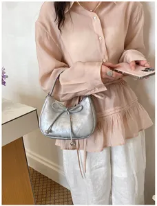 Borsa a tracolla argentata metallizzata elegante con grazioso fiocco, design di tendenza.