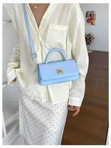 Primo piano della borsa a tracolla azzurra elegante indossata dalla modella, look quotidiano.