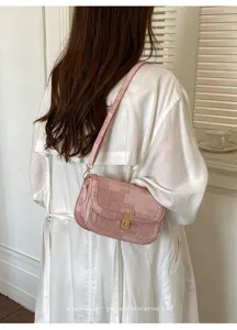 Vue détaillée d'un sac porté épaule rétro rose élégant avec une texture unique.