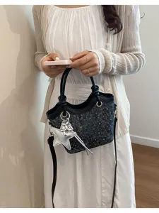 Details of Korean style tweed handbag showcasing the black trim and cute star charm decoration.