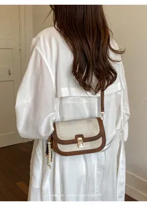 Sac bandoulière rétro pour femme avec design contrasté, serrure métallique et perles.