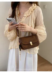 Sac à bandoulière marron rétro pour femme, élégant sac à main avec détail de serrure.