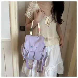 Mochila casual morada de mujer con asa trenzada y detalles de cuentas elegante moda