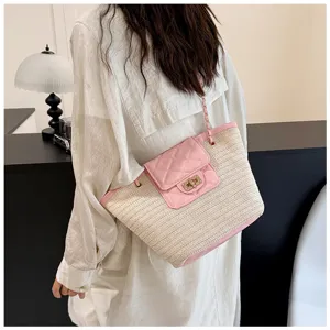Stijlvolle strooien tote tas met roze gewatteerde flap en gouden kettingriem voor dames.