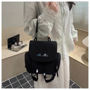 Vista detallada de la mini mochila negra con cordones de cuentas lindos y logotipo bordado.