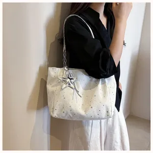Detailed view of women's white star-print shoulder bag with chain strap and cute star charm.