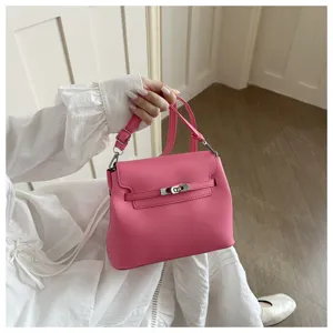 Sac à main en cuir rose avec poignée et fermoir tournant, élégant accessoire.