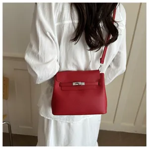 Vue détaillée d'un sac à bandoulière en cuir rouge élégant avec fermoir métallique.