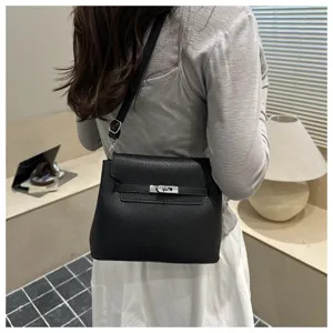 Vue detaillee du sac a main en cuir noir avec fermoir en metal en interieur.