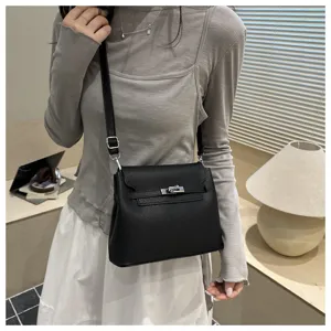 Vue détaillée d'un sac bandoulière en cuir noir avec design à rabat et serrure argentée.