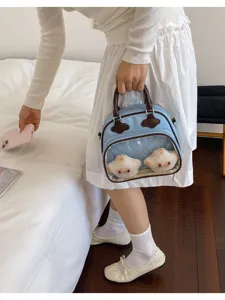 Vue détaillée d'un sac bandoulière ita bleu clair élégant avec peluches et fenêtre transparente.