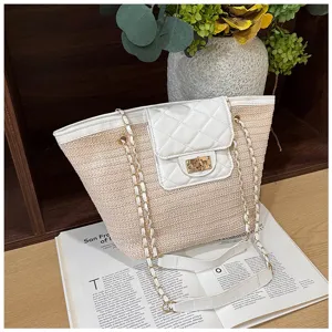 Gedetailleerd overzicht van de zomerse strooien tote tas met gewatteerde flap en ketting.