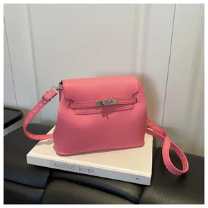 Détail sac à main bandoulière en cuir rose, design à rabat classique avec fermoir métallique.