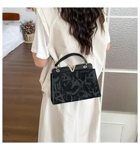 Chic black shoulder bag for women, featuring a stylish metal V clasp and trendy design.