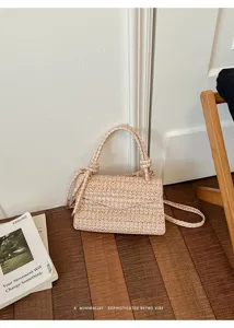 Primo piano dei dettagli della borsa a tracolla intrecciata, consistenza e metalleria.