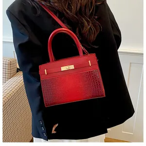 Red crocodile pattern leather handbag detail, stylish top handle bag with gold hardware lock.