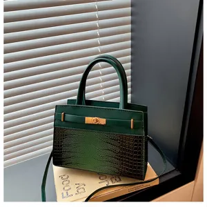 Dark green structured handbag detail showing exquisite crocodile texture and gold turn-lock clasp.