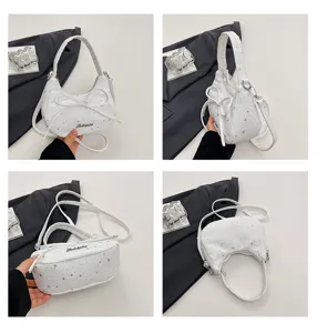 Detailed view of the stylish white star-patterned dumpling handbag with bow and shoulder strap.