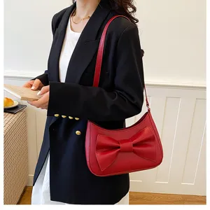 Stylish red shoulder bag with a chic bow design, perfect for casual and commuting wear.