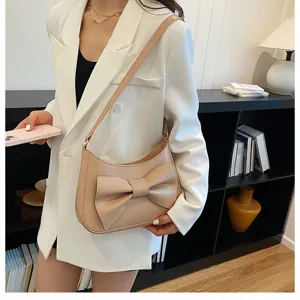 Chic beige crescent shoulder bag with a large bow detail, perfect for Korean fashion style.