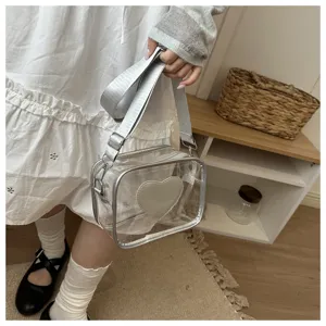 Vue détaillée du sac bandoulière transparent en PVC avec joli design de cœur et large sangle.
