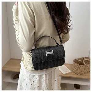 Zwarte geweven stro schoudertas met chique metalen sluiting, stijlvolle casual tas detail.