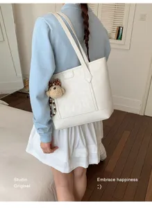 Detail view of the elegant white PU leather tote bag with cute bear pendant for daily commute.