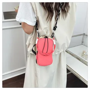 Detailansicht der trendigen koreanischen rosa Umhängetasche für Handy und Flasche, Outdoor.